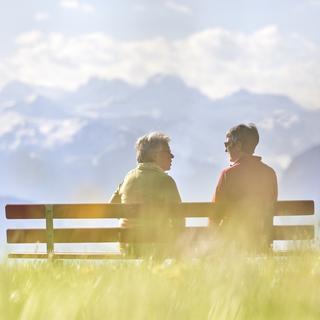 Deux personnes discutent sur un banc public à Kriens (LU) le 10 avril 2017. [Keystone - Christof Schuerpf]