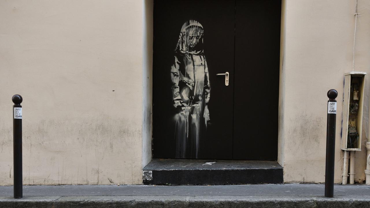 Oeuvre au pochoir attribuée à Banksy sur une porte arrière du Bataclan, "hommage aux victimes du 13/11", volée dans la nuit du 26 au 27 janvier. [Keystone - EPA/JULIEN DE ROSA]