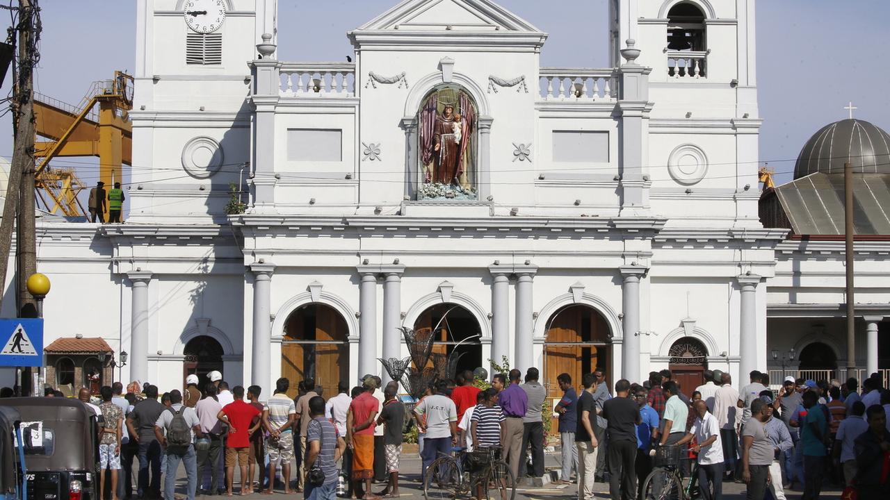 Des Sri Lankais sont réunis devant l'église St-Antoine à Kochchikade, Colombo, le 22 avril. [EPA/Keystone - M. A. Pushpa Kumara]