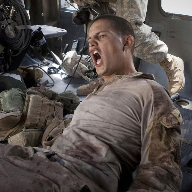 Le caporal Blas Trevino, du 5e Corps des Marines, crie alors qu'il est secouru par un hélicoptère d'évacuation médicale de l'armée américaine après avoir reçu une balle dans le ventre près de Sangin, au sud de l'Afghanistan, le samedi 11 juin 2011. [Keystone/AP Photo - Anja Niedringhaus]