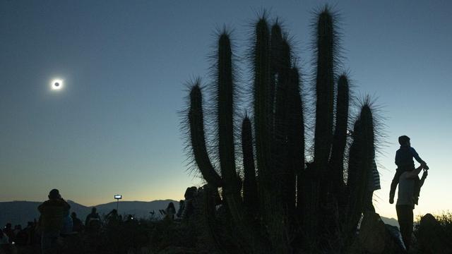 Des gens admirent l'éclipse solaire depuis La Higuera, près de l'observatoire de La Silla, au Chili, le 2 juillet 2019. [Keystone - AP Photo/Esteban Felix]