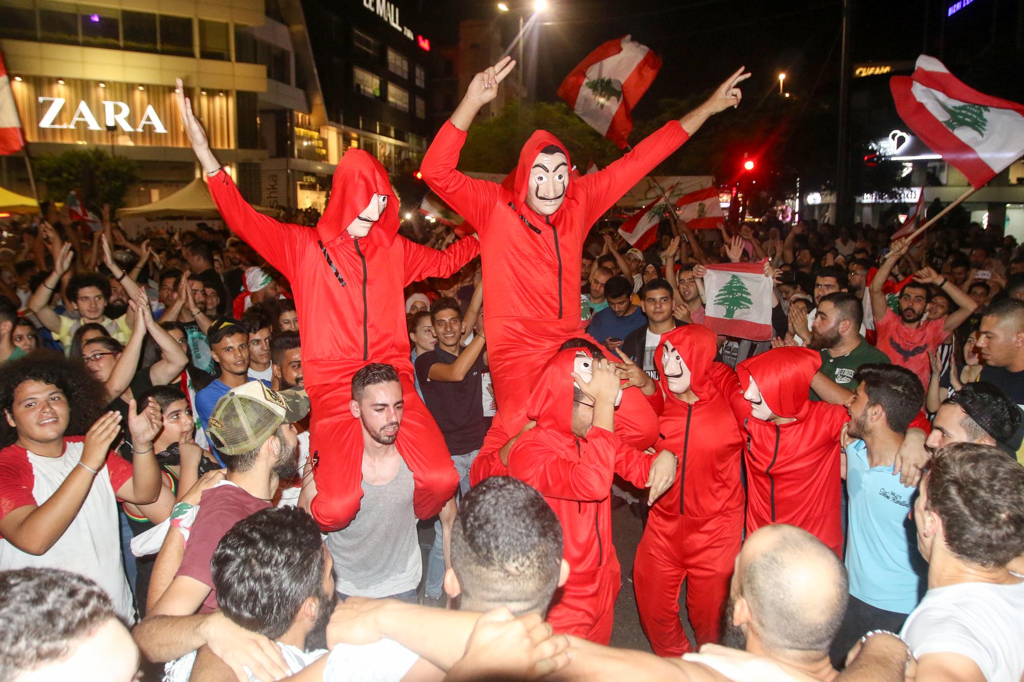 Des manifestants libanais portent le masque et la combinaison des braqueurs de la série espagnole "La Casa de Papel", dans les rues de Sidon, le 19 octobre 2019. [afp - Mahmoud Zayyat]