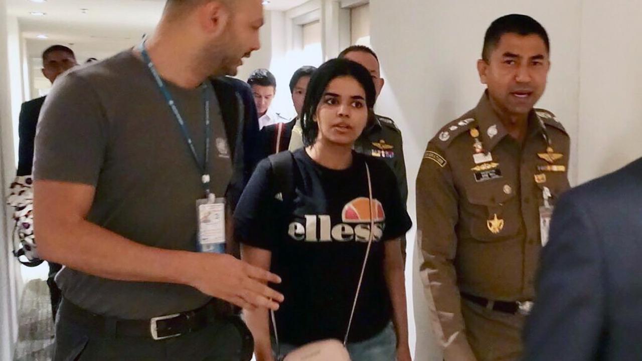 Photo du service de l'Immigration thaïlandaise montrant Rahaf Mohammed Al-Qunun quitter l'aéroport aux côtés d'une membre du HCR. [Keystone - Bureau de l'immigration thaïlandaise]