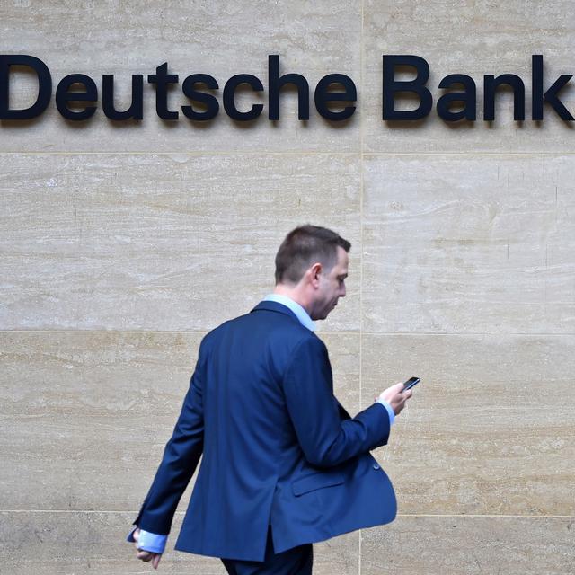 Un homme passe devant le logo de Deutsche Bank. [EPA-Keystone - Facundo Arrizabalaga]