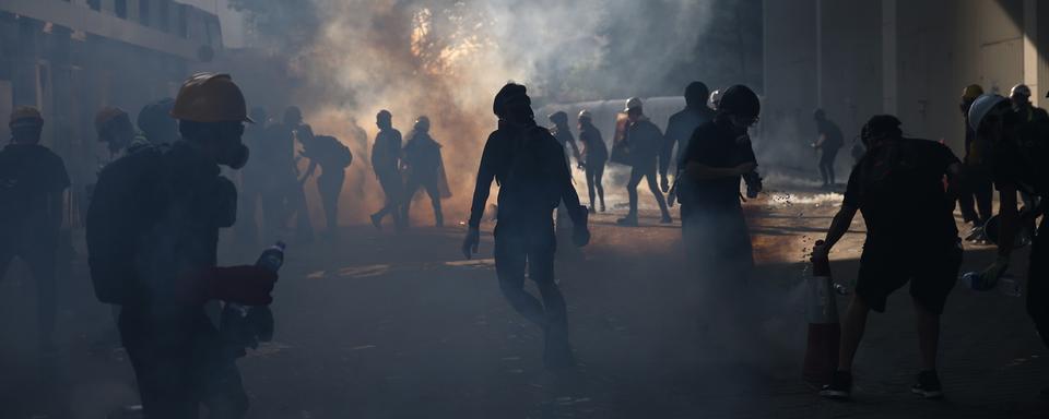 Des manifestants sont pris dans les gaz lacrymogènes de la police, à Hong Kong, le 5 août 2019. [Keystone/epa - Jérôme Favre]