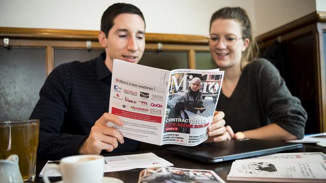 Les journalistes Fabien Feissli et Samantha Lunder lors d'une séance de rédaction du nouveau journal Micro, au café de Grancy à Lausanne. [Keystone - Jean-Christophe Bott]