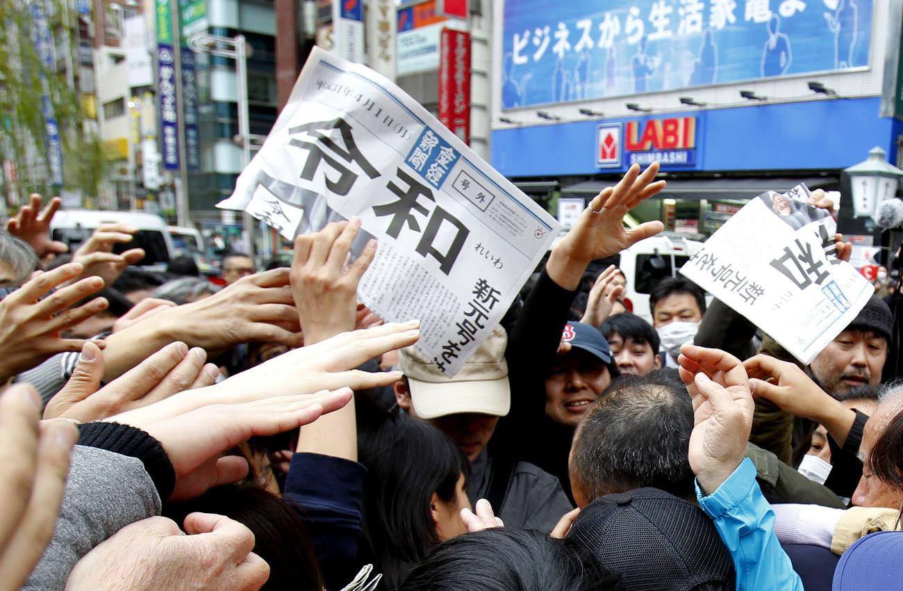 Des Japonais se ruent à Tokyo sur une édition spéciale du Sankei Shimbun, un journal donnant le nouveau nom de l'ère impériale, "Reiwa". [Keystone/ap photo - Koji Sasahara]