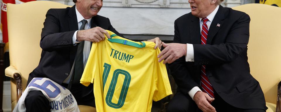 Jair Bolsonaro a remis à Donald Trump un maillot de l'équipe brésilienne à son nom lors d'une visite à Washington en mars 2019. [AP/Keystone - Evan Vucci]