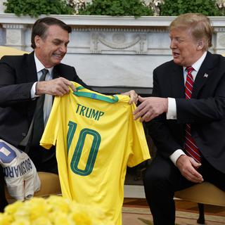 Jair Bolsonaro a remis à Donald Trump un maillot de l'équipe brésilienne à son nom lors d'une visite à Washington en mars 2019. [AP/Keystone - Evan Vucci]
