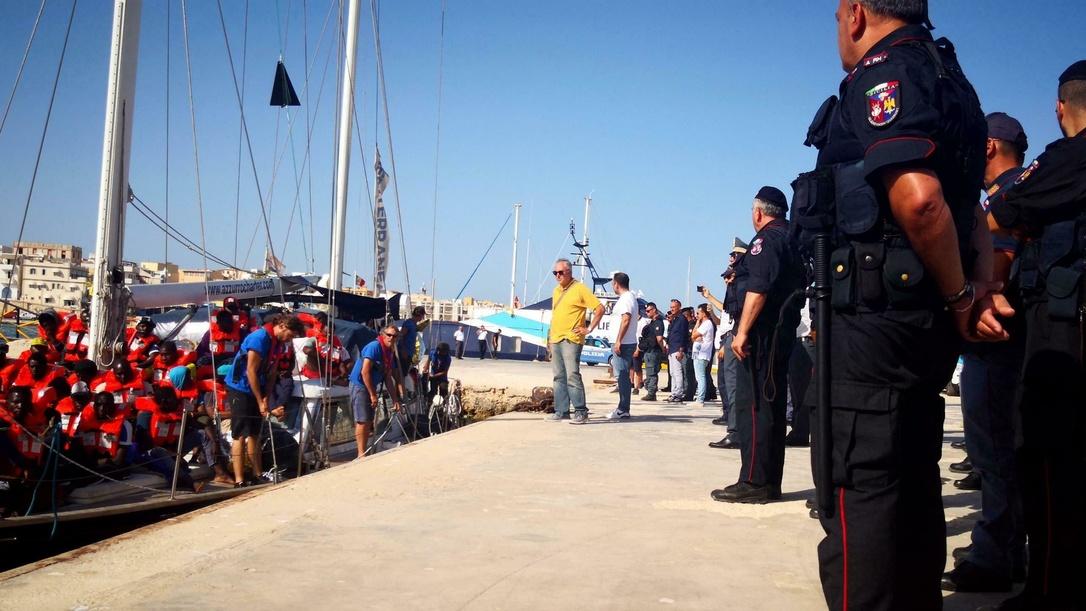 D'importantes forces de police attendaient l'Alex, un voilier humanitaire transportant 41 migrants. [Keystone - Elio Desiderio/ANSA via AP]