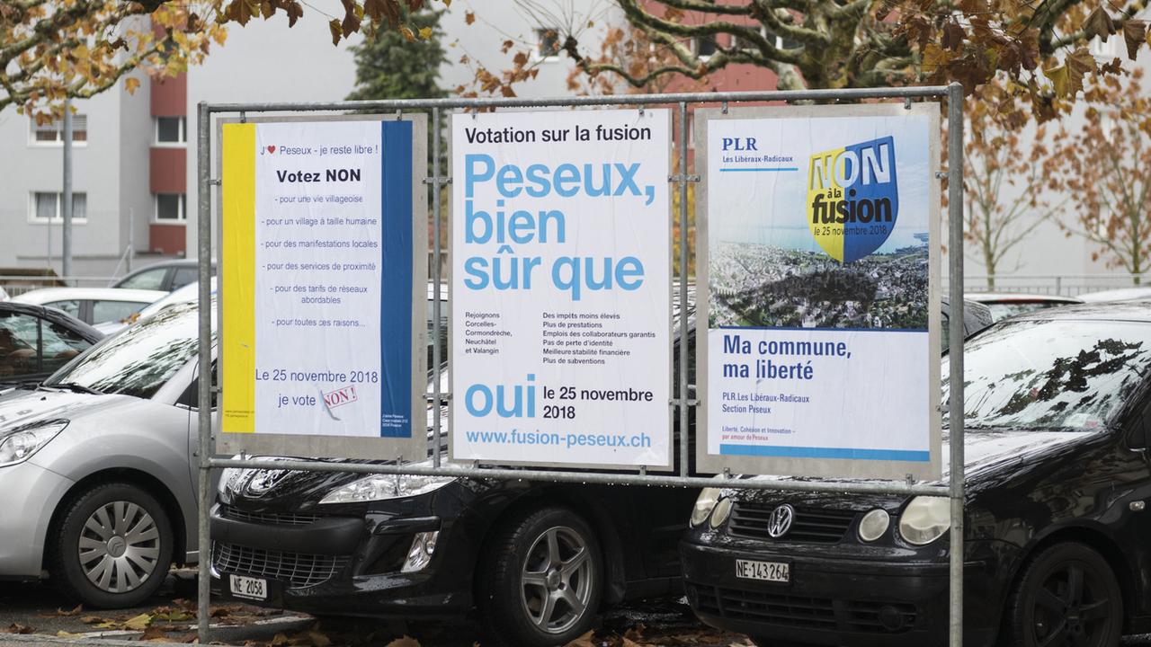 Les affiches invitant les habitants de Peseux à voter "oui" ou "non" à la fusion avec Neuchâtel. [Keystone - Adrien Perritaz]