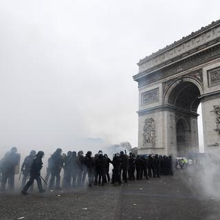 La police fait face aux "gilets jaunes" sous l'arc de triomphe de l'Etoile à Paris. [AFP - Bertrand Guay]