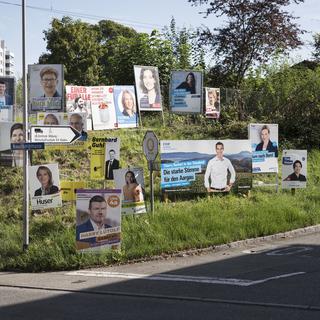 Les affiches de campagne de différent.e.s candidat.e.s aux élections fédérales photographiées mi-septembre à Baden (AG). [Keystone - Christian Beutler]