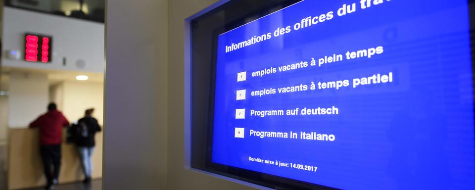 Un écran indique les emplois vacant dans le hall de l'Office Cantonal de l'emploi à Genève. [Keystone - Martial Trezzini]