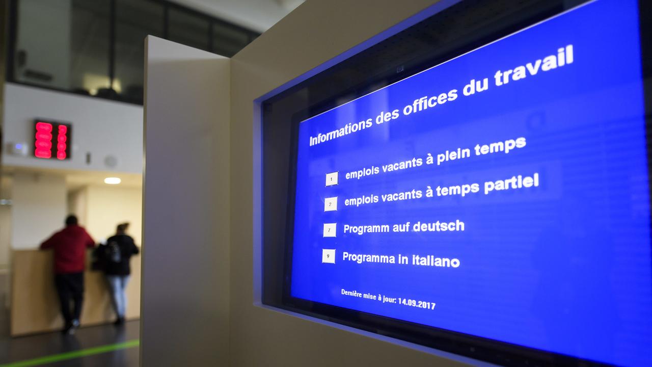 Un écran indique les emplois vacant dans le hall de l'Office Cantonal de l'emploi à Genève. [Keystone - Martial Trezzini]