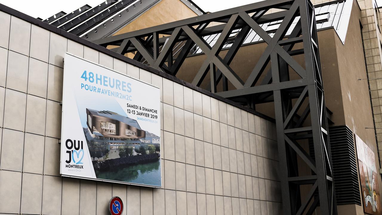 Une affiche appelant à voter pour la rénovation du Centre des congrès de Montreux sur le bâtiment concerné, en janvier 2019. [Keystone - Jean-Christophe Bott]