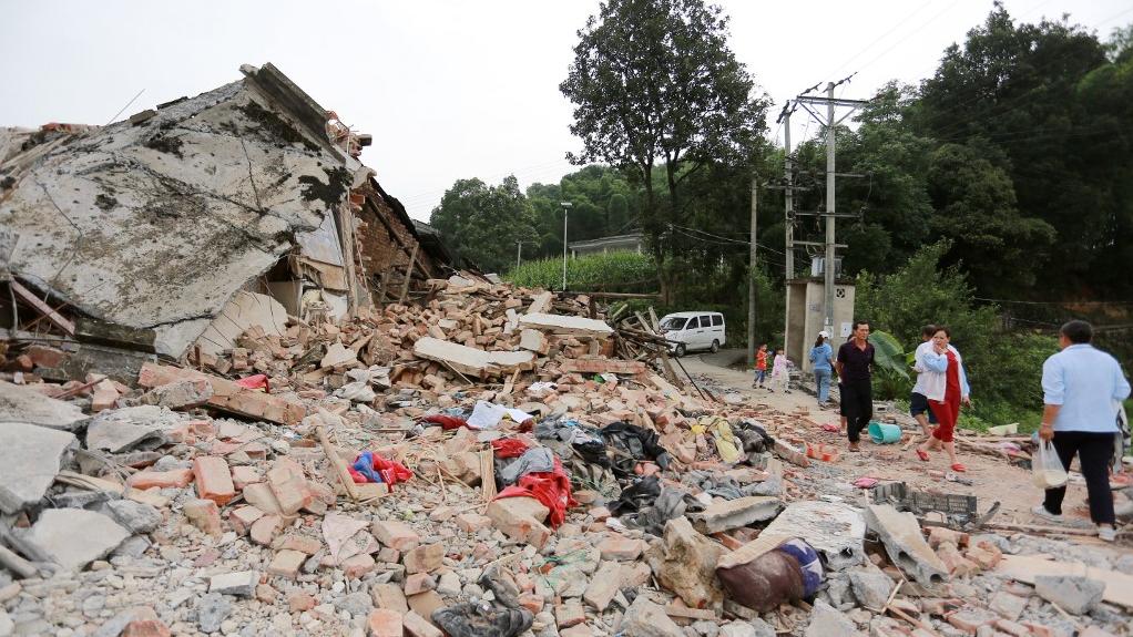 Des villageois contemplent les débris au sud-ouest de la province du Sichuan. [AFP/ImagineChina - Tang Jinghao]