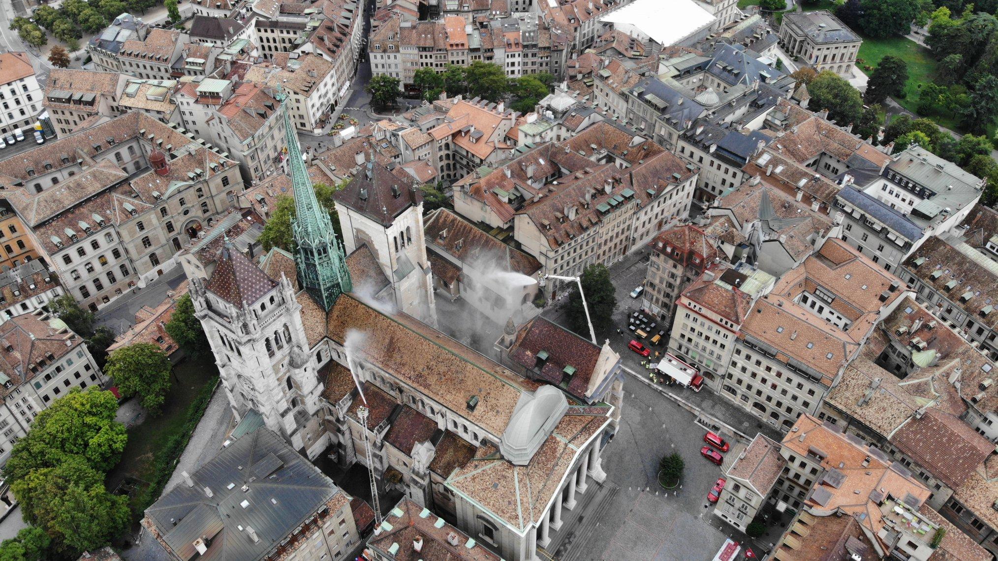 Alors qu'une échelle de trente mètres munie d'un canon à eau se déploie à la hauteur de la fumée, une seconde est installée dans l'étroite rue du Cloître, de l'autre côté de la cathédrale. [SIS/Ville de Genève - T. Hottinger/J. Gregorio]