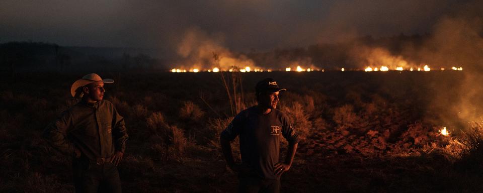 Des ouvriers agricoles constatent la progression des flammes dans le Mato Grosso au Brésil. [Keystone/AP Photo - Leo Correa]