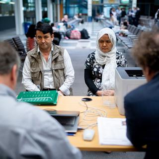 Une famille et un interprète dans un office pour réfugiés en Allemagne (image d'illustration). [Keystone - Kay Nietfeld/dpa]