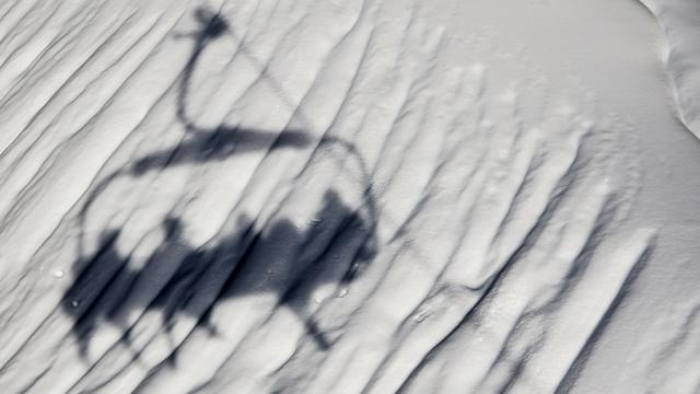 L'ombre d'un télésiège du domaine skiable de Villars, dans les Alpes vaudoises. [Keystone - Jean-Christophe Bott]