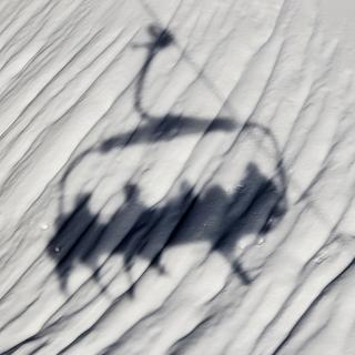 L'ombre d'un télésiège du domaine skiable de Villars, dans les Alpes vaudoises. [Keystone - Jean-Christophe Bott]