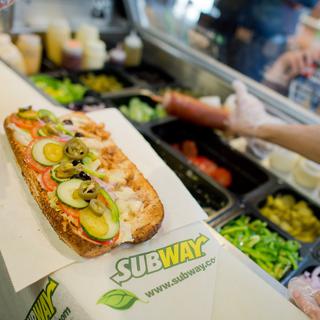 Un employé assemble un sandwich dans un restaurant de la chaîne de fast-food américaine Subway. [AFP - Julian Stratenschulte]