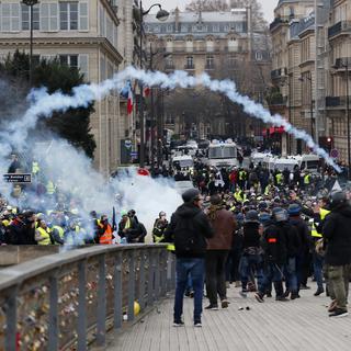 La police lance du gaz lacrymogène sur des protestataires des "gilets jaunes" au bord de la Seine à Paris le 5 janvier 2019. [Keystone - EPA/IAN LANGSDON]