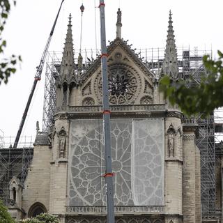 Un filet recouvre la rosace de la cathédrale Notre-Dame. [Keystone - Thibault Camus]