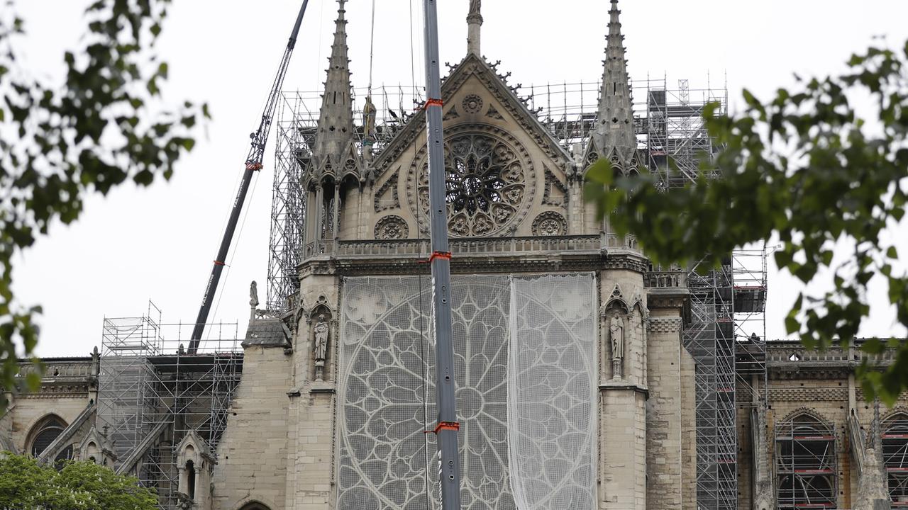 Un filet recouvre la rosace de la cathédrale Notre-Dame. [Keystone - Thibault Camus]