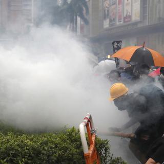 Des manifestants portent des masques pour se protéger des gaz lacrymogènes lancés par la police hongkongaise. [EPA/Keystone - Roman Pilipey]