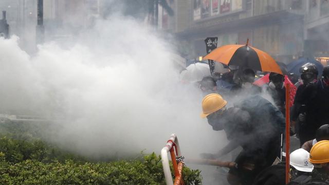 Des manifestants portent des masques pour se protéger des gaz lacrymogènes lancés par la police hongkongaise. [EPA/Keystone - Roman Pilipey]