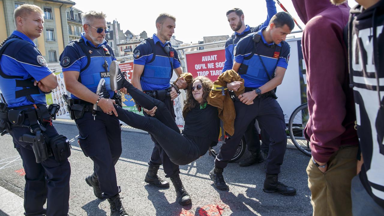 Une activiste évacuée par la police sur le pont Bessières de Lausanne. [Keystone - Salvatore Di Nolfi]