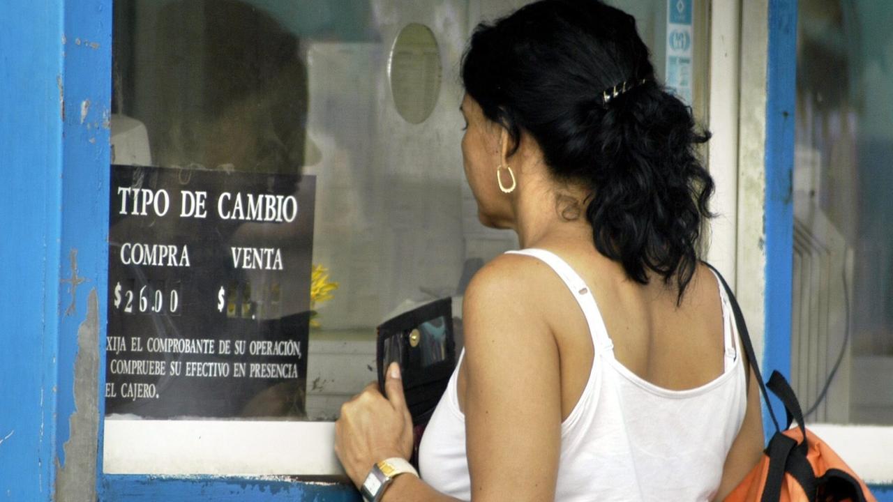 Une femme devant une banque à Cuba. [Keystone - EPA/Alejandro Ernesto]