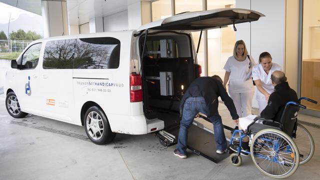 Du personnel médical et de Transport Handicap accompagnent le premier patient arrivant à l'hôpital Riviera-Chablais le 4 novembre 2019. [Keystone - Laurent Gillieron]