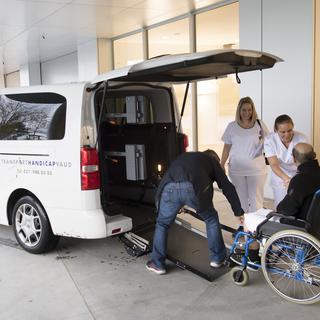 Du personnel médical et de Transport Handicap accompagnent le premier patient arrivant à l'hôpital Riviera-Chablais le 4 novembre 2019. [Keystone - Laurent Gillieron]