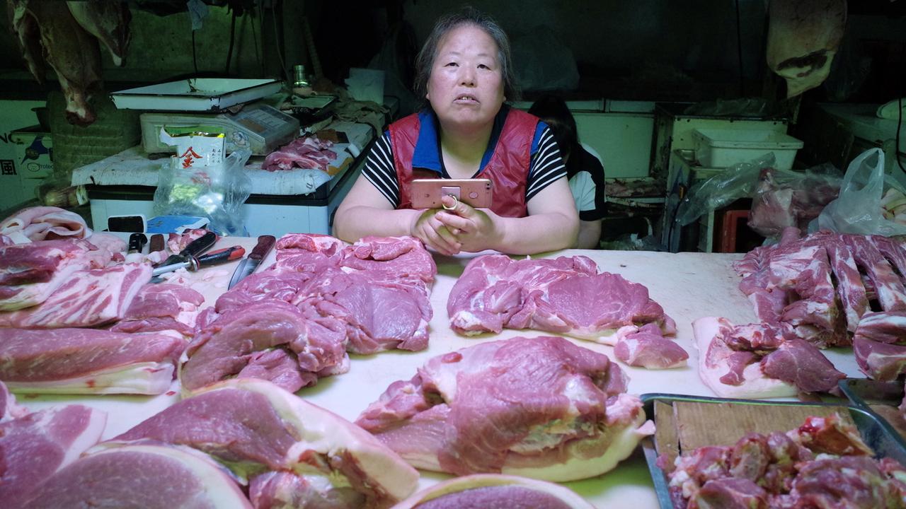 Une vendeuse de porc sur un marché de Pékin. [Epa - Wu Hong]