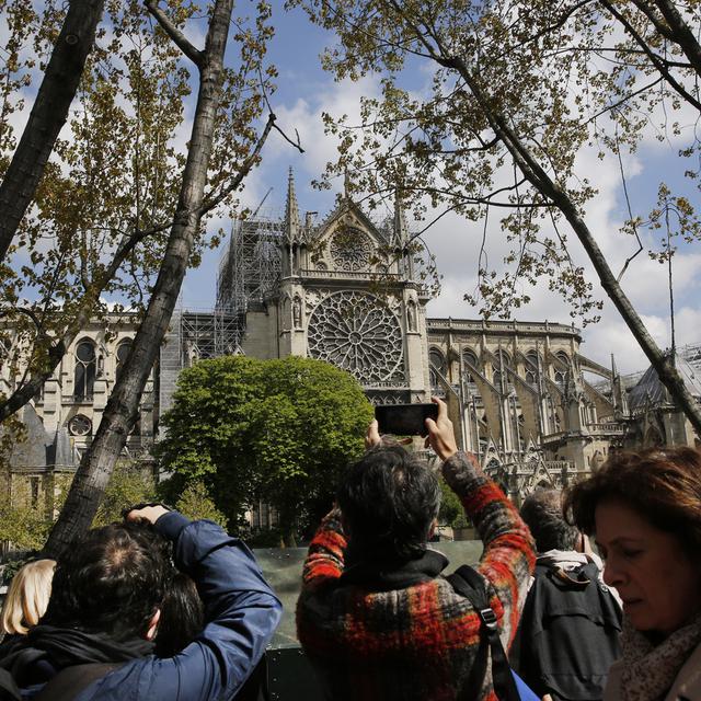 Les visiteurs affluent dans les églises parisiennes depuis l'incendie qui a ravagé Notre-Dame. [AP Photo/Keystone - Christophe Ena]