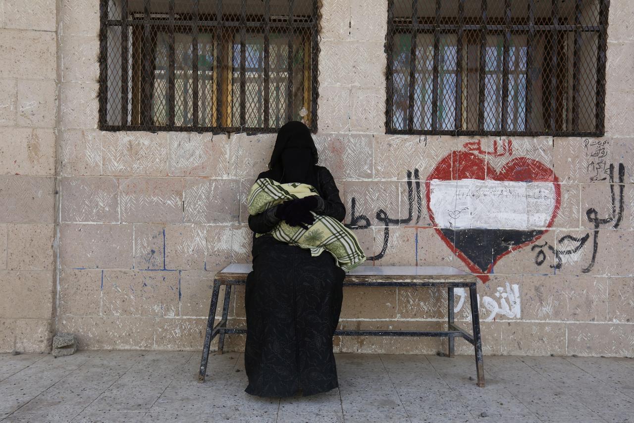 Une femme et son enfant attendent des rations de nourriture à Sanaa, capitale du Yemen, le 14 février 2019. [Keystone/epa - Yahya Arhab]