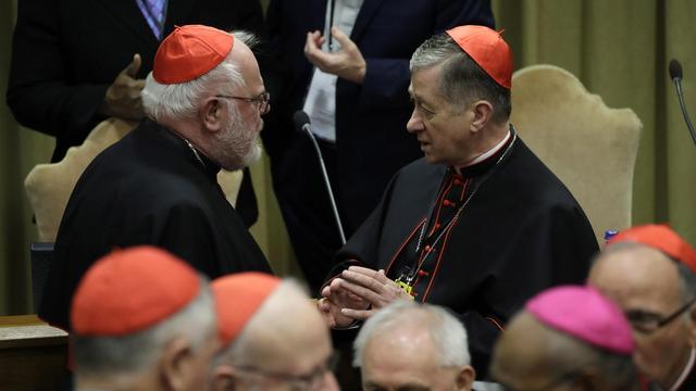 Le cardinal Reinhard Marx (à gauche), ici en discussion avec l'archevêque Blase J.Cupich. [Keystone - EPA/Alessandra Tarantino]