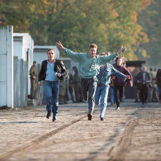 Trois jeunes de Berlin-Est traversent la frontière vers Berlin-Ouest. [Keystone/DPA]