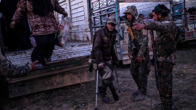 Un homme suspecté d'appartenir au groupe Etat islamique va être fouillé par des membres des Forces démocratiques syriennes à Baghouz. [AFP - Bulent Kilic]