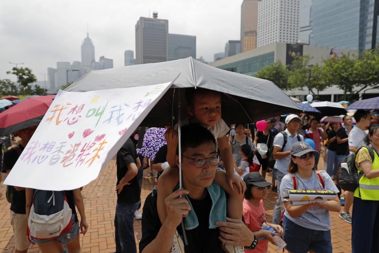 Des familles défilent dans les rues de Hong Kong pour protester contre le gouvernement de la ville. [Keystone - Vincent Thian]