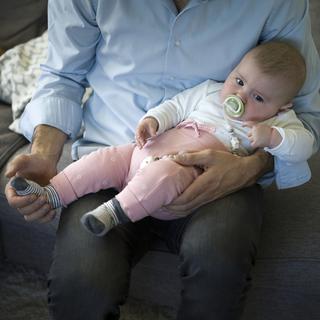 Un père avec son enfant de 5 mois, photographié dans le canton de Zurich (image d'illustration). [Keystone - Gaëtan Bally]