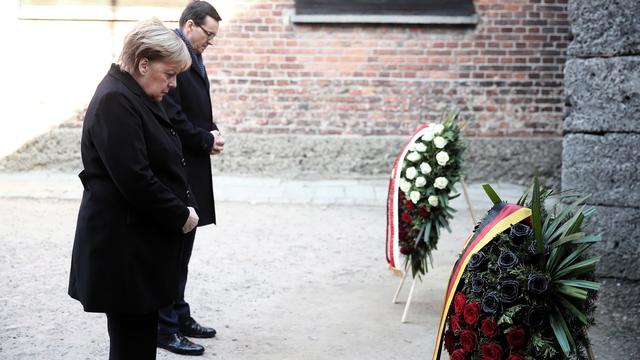 Angela Merkel et le Premier ministre polonais Mateusz Morawiecki se recueille lors de leur visite du camp de concentration d'Auschwitz, le 6 décembre 2019. [Keystone - Lukas Gagaulski]