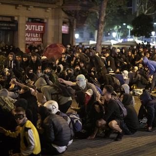 Des manifestants se mettent à couvert durant des affrontements avec la police à Barcelone, vendredi 18 octobre 2019. [Keystone/ap photo - Emilio Morenatti]