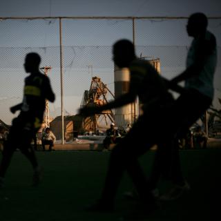 Des jeunes hommes jouent au football dans un camps de réfugiés en Libye. [AP-Keystone - Manu Brabo]