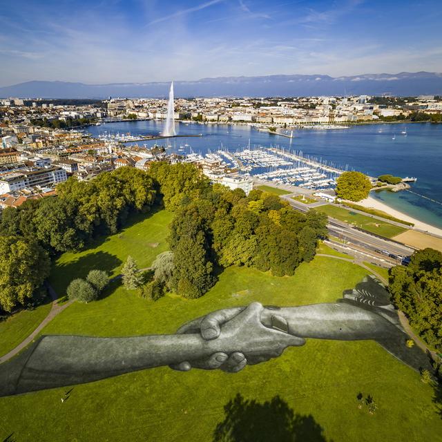 La fresque peinte sur la pelouse du parc La Grange, à Genève, par l'artiste français Saype. [Keystone - EPA/VALENTIN FLAURAUD]