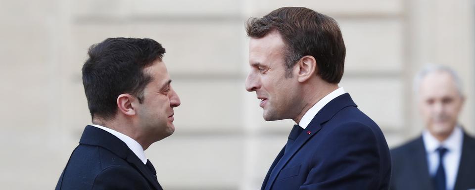 Emannuel Macron salue le président ukrainien Volodymyr Zelensky. [EPA/Keystone - Ian Langsdon]