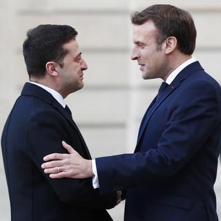 Emannuel Macron salue le président ukrainien Volodymyr Zelensky. [EPA/Keystone - Ian Langsdon]